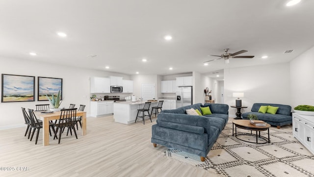 living area with recessed lighting, baseboards, and light wood finished floors