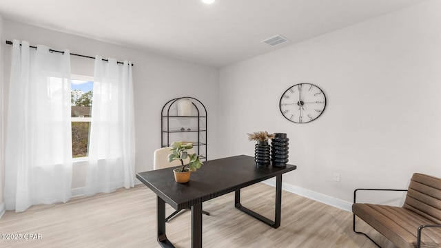 home office with visible vents, baseboards, and light wood-style flooring