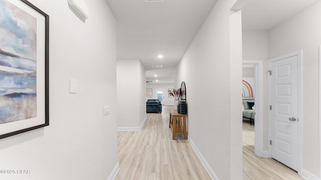 hallway featuring visible vents, recessed lighting, light wood-type flooring, and baseboards