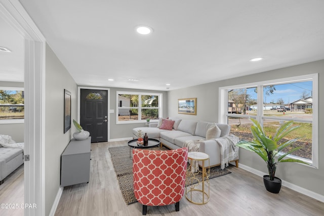 living room featuring recessed lighting, baseboards, and light wood-style flooring