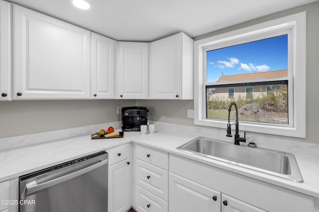 kitchen featuring dishwasher, white cabinets, and a sink