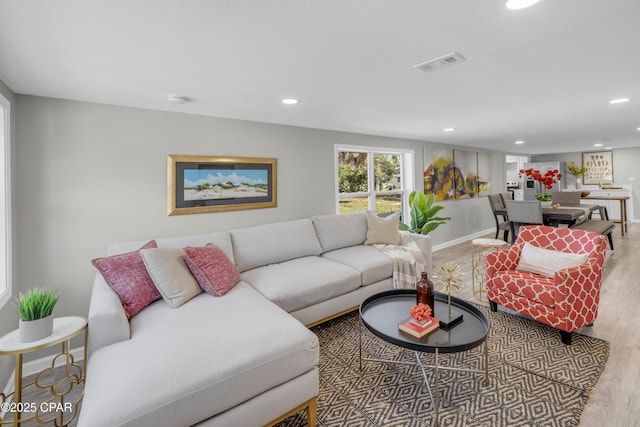 living area featuring recessed lighting, visible vents, baseboards, and wood finished floors