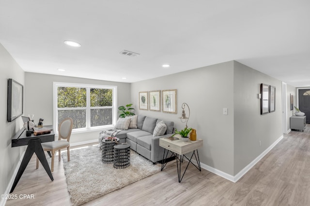 living room with recessed lighting, light wood-type flooring, baseboards, and visible vents