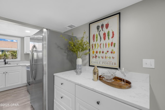 bathroom with vanity, wood finished floors, and visible vents