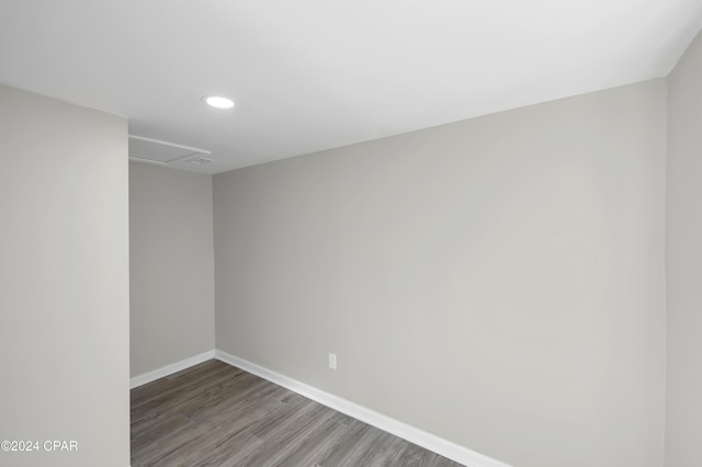 spare room with attic access, recessed lighting, wood finished floors, and baseboards