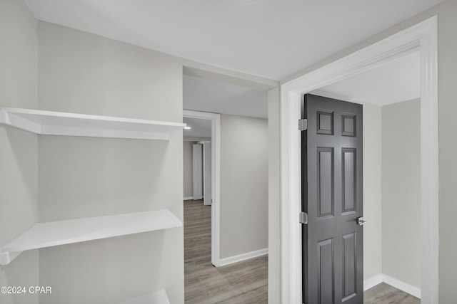 hallway with wood finished floors and baseboards