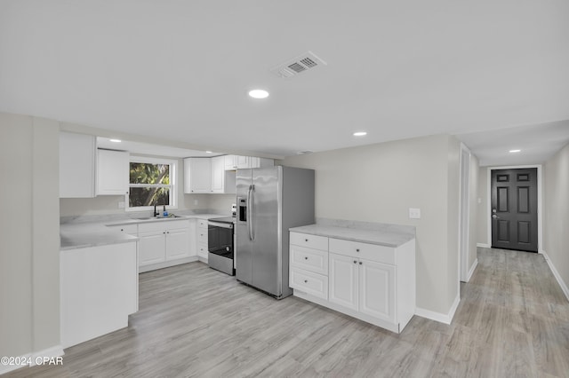 kitchen featuring sink, white cabinetry, stainless steel appliances, and light hardwood / wood-style flooring