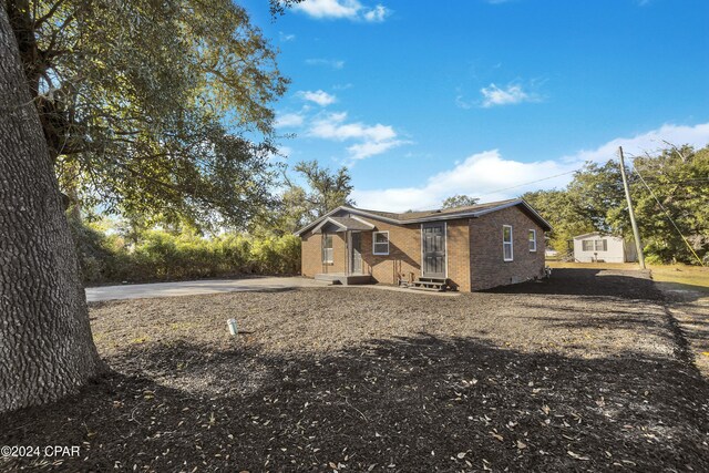 view of front of property featuring a shed