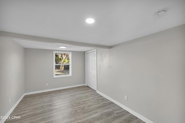 spare room featuring baseboards and wood finished floors