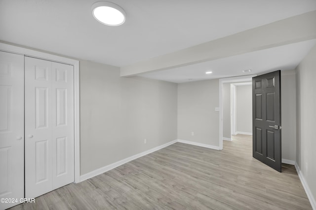 finished below grade area featuring light wood-style floors and baseboards
