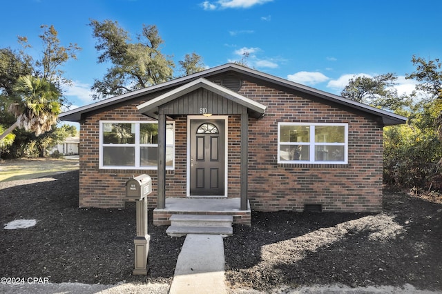 bungalow featuring brick siding