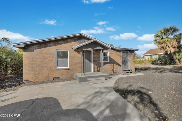 view of front facade featuring crawl space and brick siding
