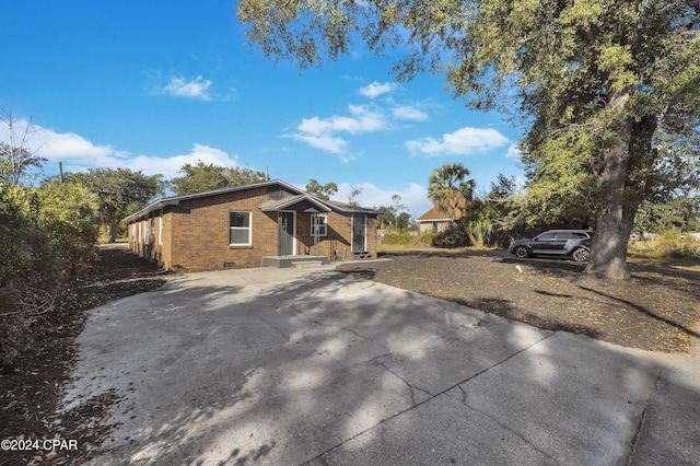 view of front of home featuring crawl space and brick siding