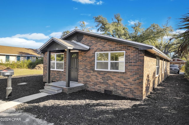 bungalow featuring brick siding