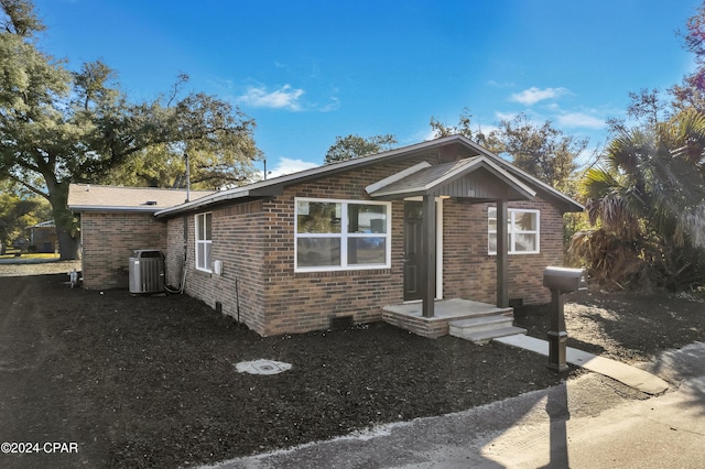 view of front of home featuring central air condition unit and brick siding