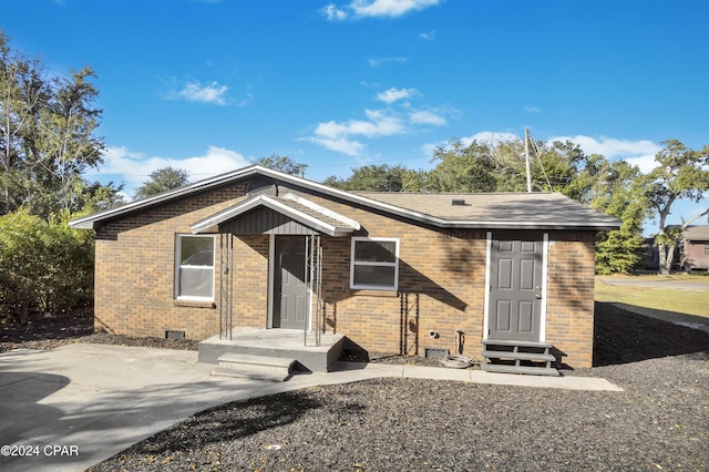 view of front facade with brick siding and crawl space