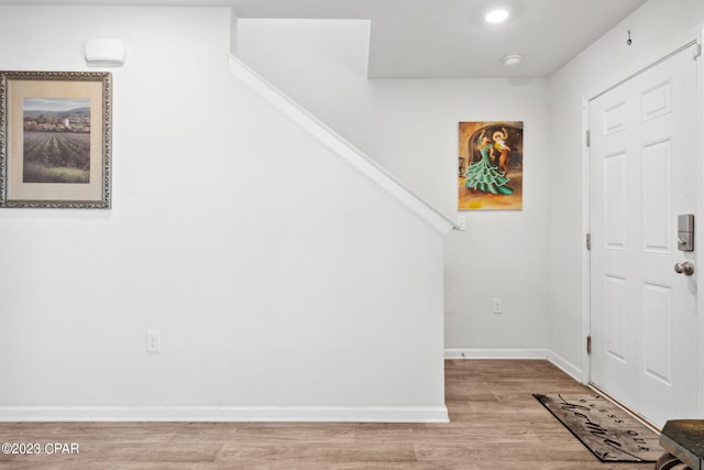 foyer entrance featuring light wood-style flooring and baseboards