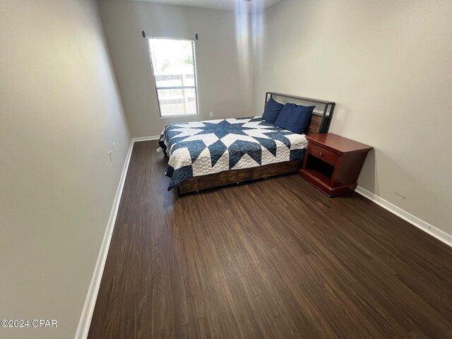 bedroom with dark hardwood / wood-style floors