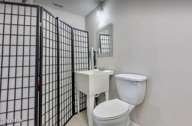 bathroom with toilet and tile patterned flooring