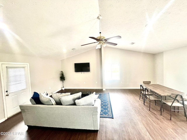 living room with hardwood / wood-style flooring, vaulted ceiling, a textured ceiling, and a healthy amount of sunlight