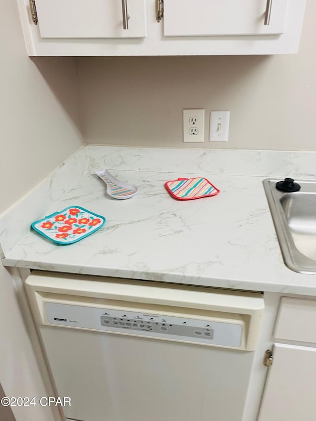 interior details featuring white cabinets, sink, and dishwasher