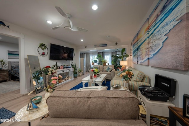 living room with ceiling fan and light hardwood / wood-style flooring