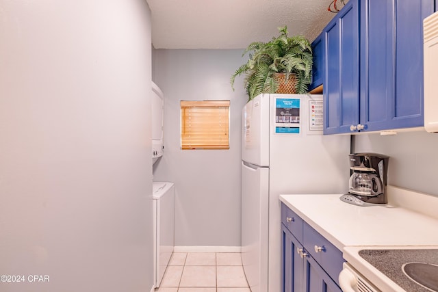 kitchen with stove, light tile patterned floors, stacked washing maching and dryer, and blue cabinets