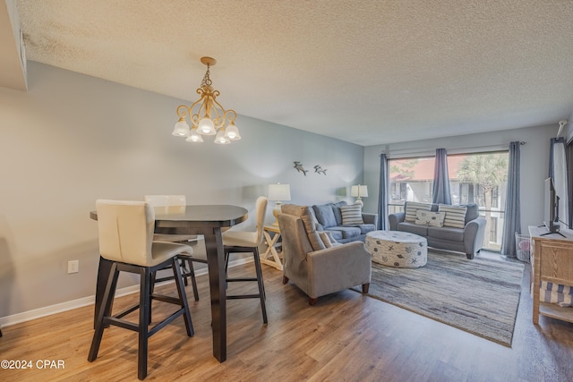 dining area with a chandelier, a textured ceiling, and hardwood / wood-style flooring