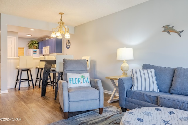 living room featuring light wood-type flooring and an inviting chandelier