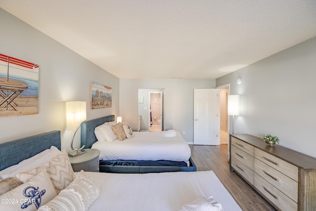 bedroom featuring hardwood / wood-style flooring and a textured ceiling