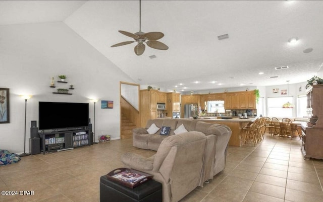 tiled living room featuring ceiling fan and high vaulted ceiling