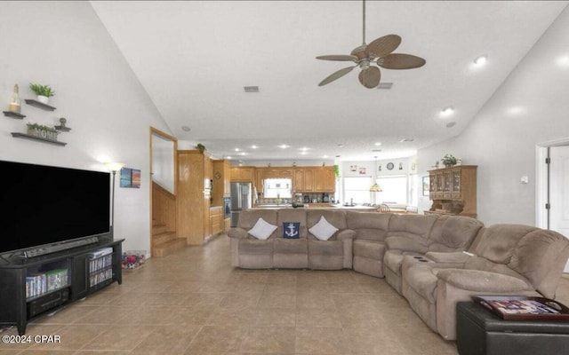 living room with ceiling fan and high vaulted ceiling