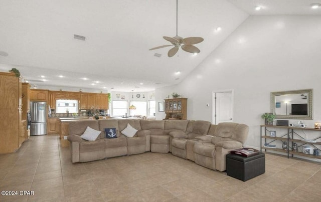 tiled living room featuring ceiling fan and high vaulted ceiling