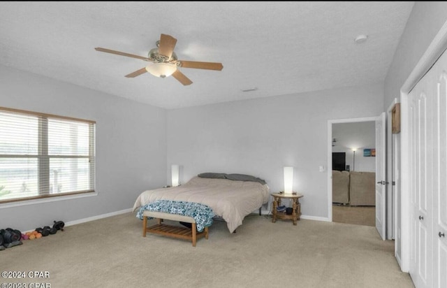 bedroom featuring light carpet, ceiling fan, and a closet