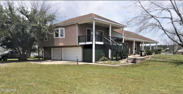 rear view of property with a garage and a lawn