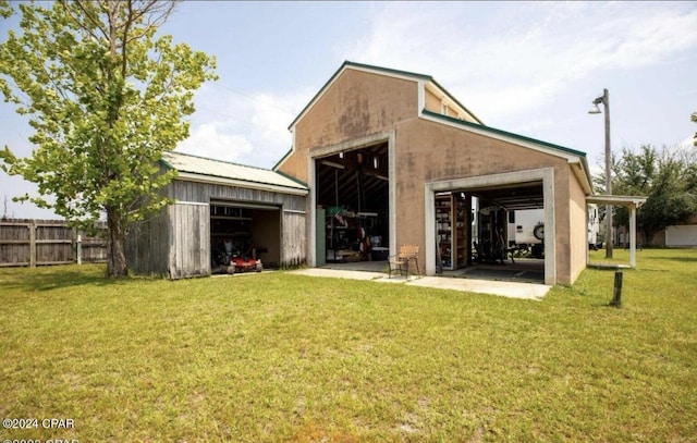 back of property with a lawn and an outdoor structure