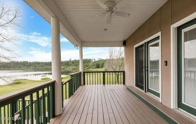 wooden deck with ceiling fan and a water view