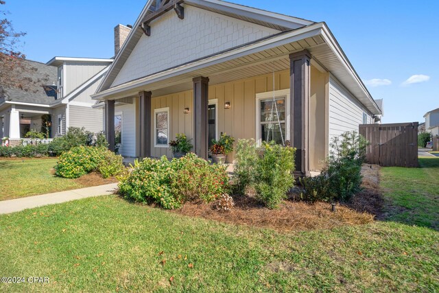 view of front of property featuring covered porch and a front yard