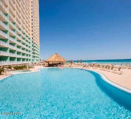 view of pool featuring a view of the beach and a water view