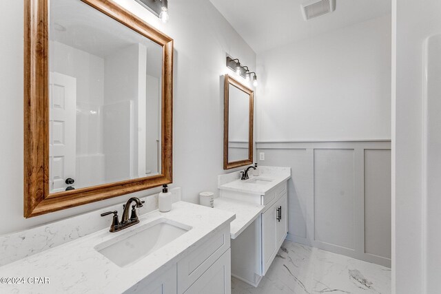 bathroom featuring a sink, visible vents, marble finish floor, and wainscoting