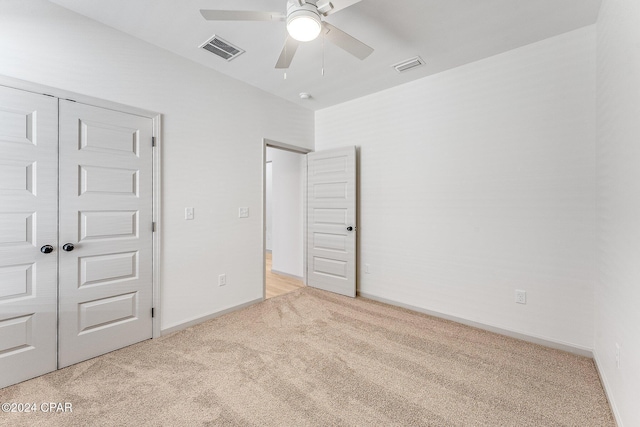 unfurnished bedroom with visible vents, baseboards, light colored carpet, and a closet