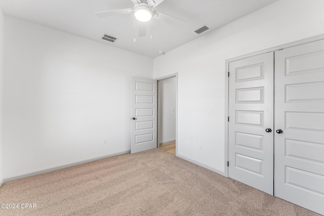 unfurnished bedroom featuring baseboards, visible vents, a closet, and light carpet