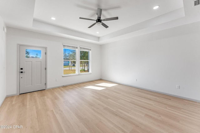 entryway with a tray ceiling, recessed lighting, light wood finished floors, and ceiling fan