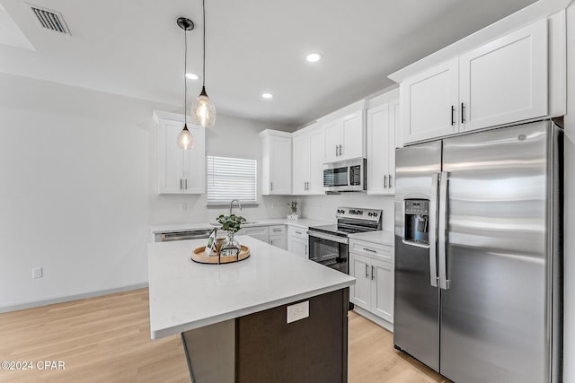 kitchen with visible vents, a kitchen island, light wood-style flooring, stainless steel appliances, and white cabinets