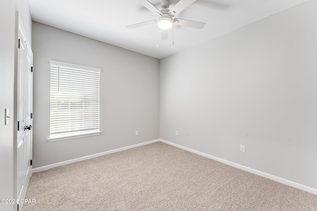 carpeted empty room featuring a ceiling fan and baseboards