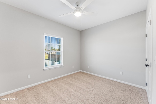 carpeted spare room with baseboards and ceiling fan