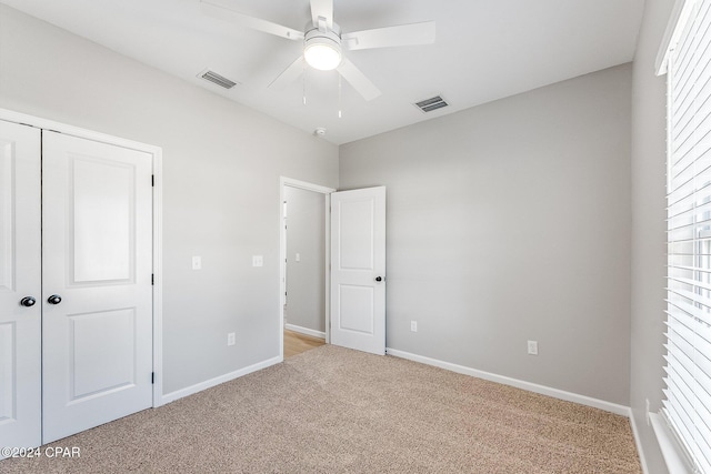 unfurnished bedroom with light carpet, visible vents, and baseboards