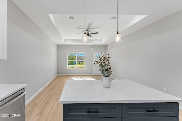 kitchen with light wood finished floors, open floor plan, dishwasher, gray cabinets, and a raised ceiling