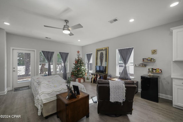 bedroom with ceiling fan, light hardwood / wood-style flooring, and refrigerator