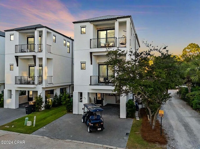 view of front of property featuring stucco siding, driveway, and metal roof